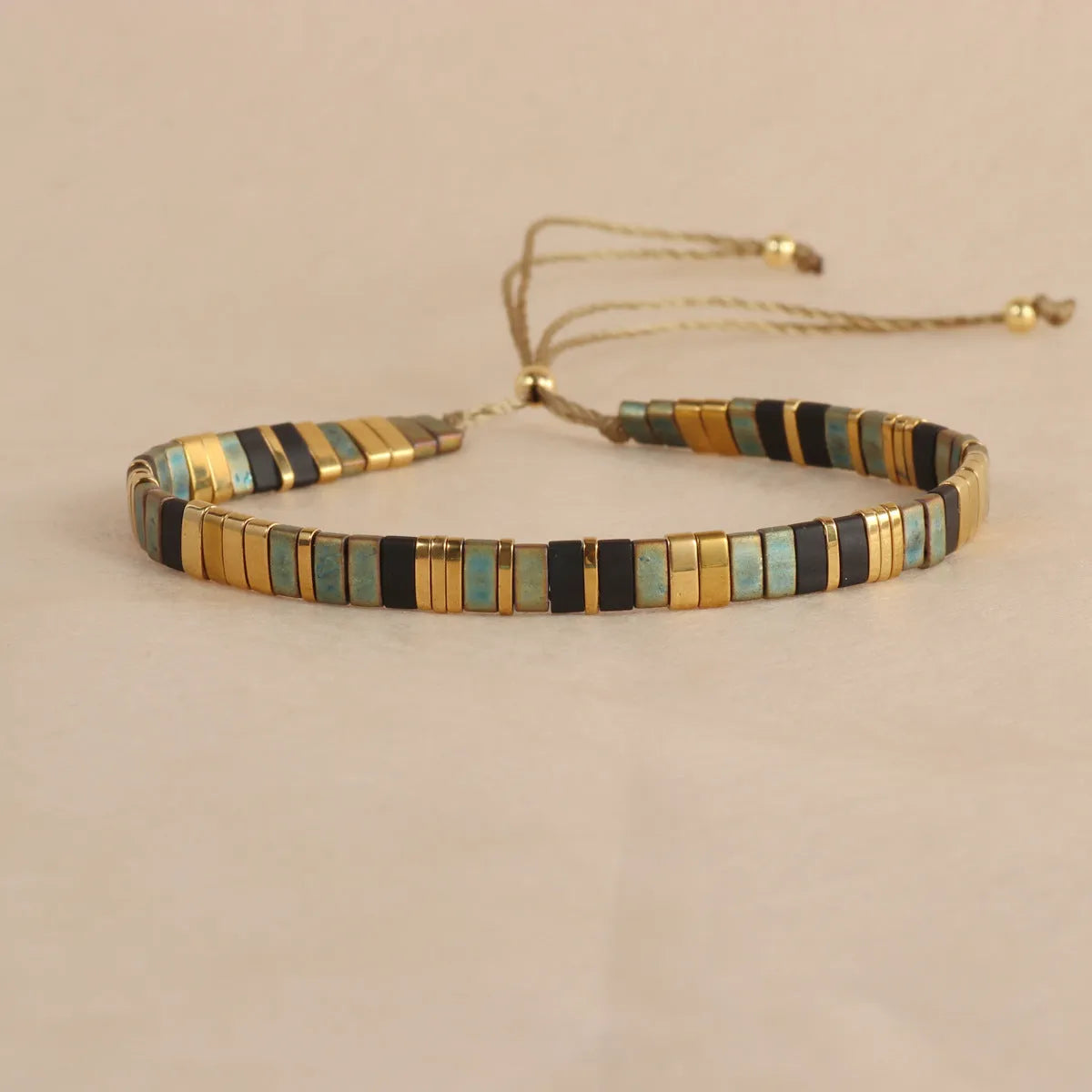 Geometric pull bead bracelet in milky white glass beads on a wrist.
