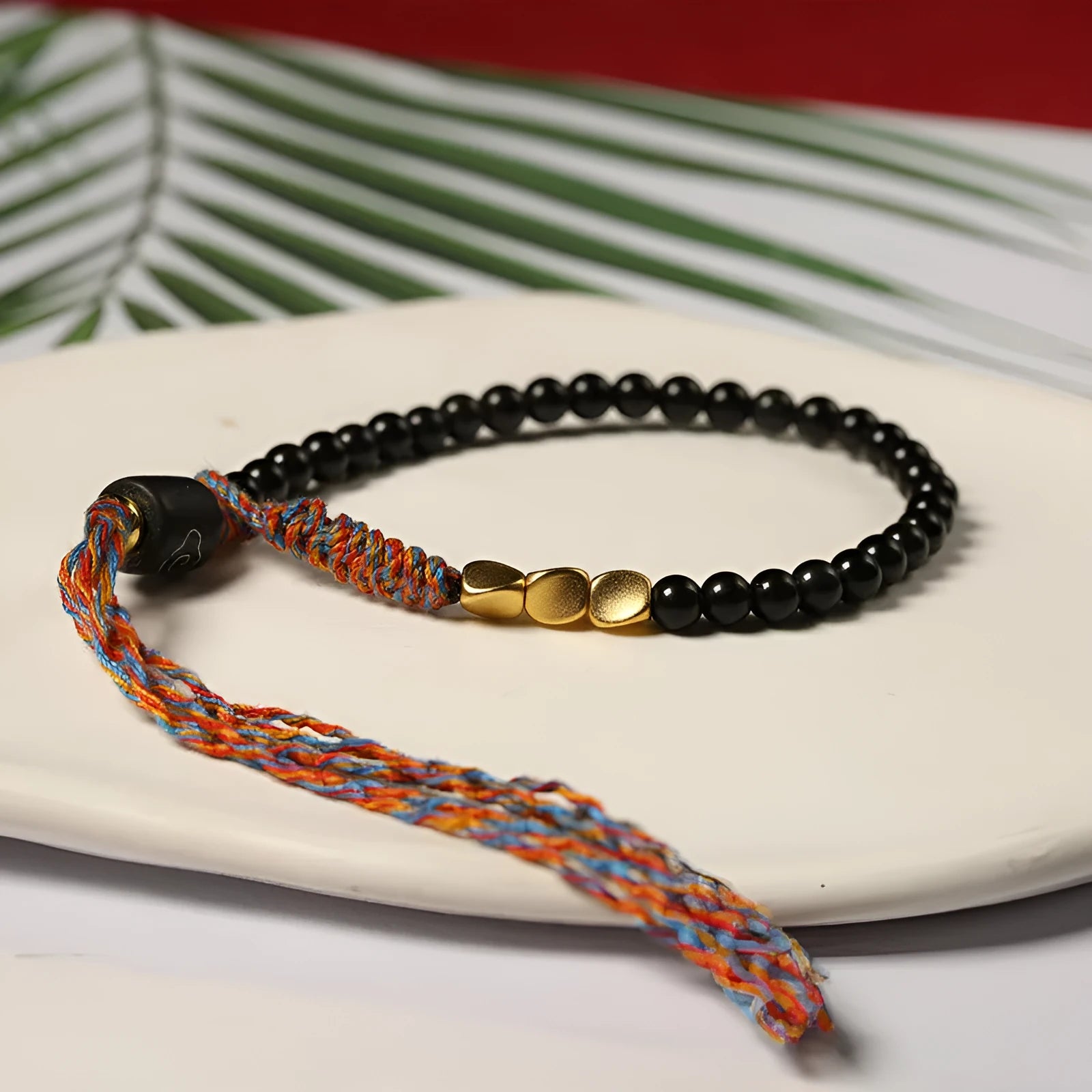 Hand-woven obsidian carrying strap bracelet showing textured surface and 4mm width