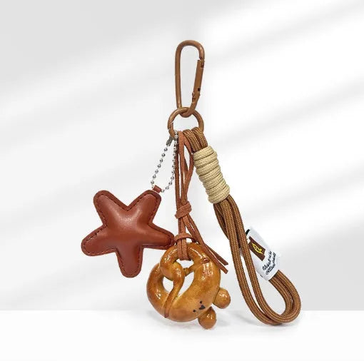 Handmade resin handbag pendant with soda bread designs including cartoon croissant and brown stars