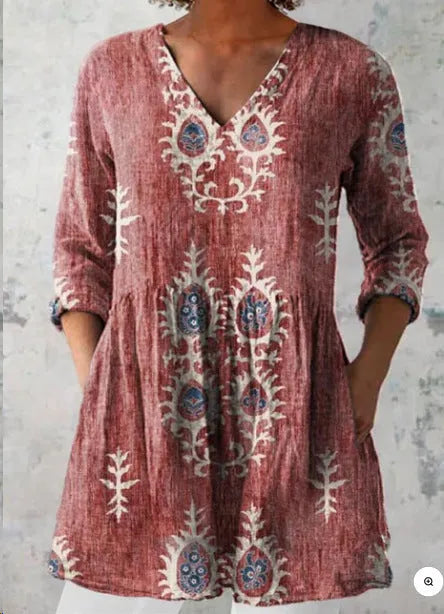 A woman wearing a loose-fitting printed dress with 3/4 sleeves and a wide waist.