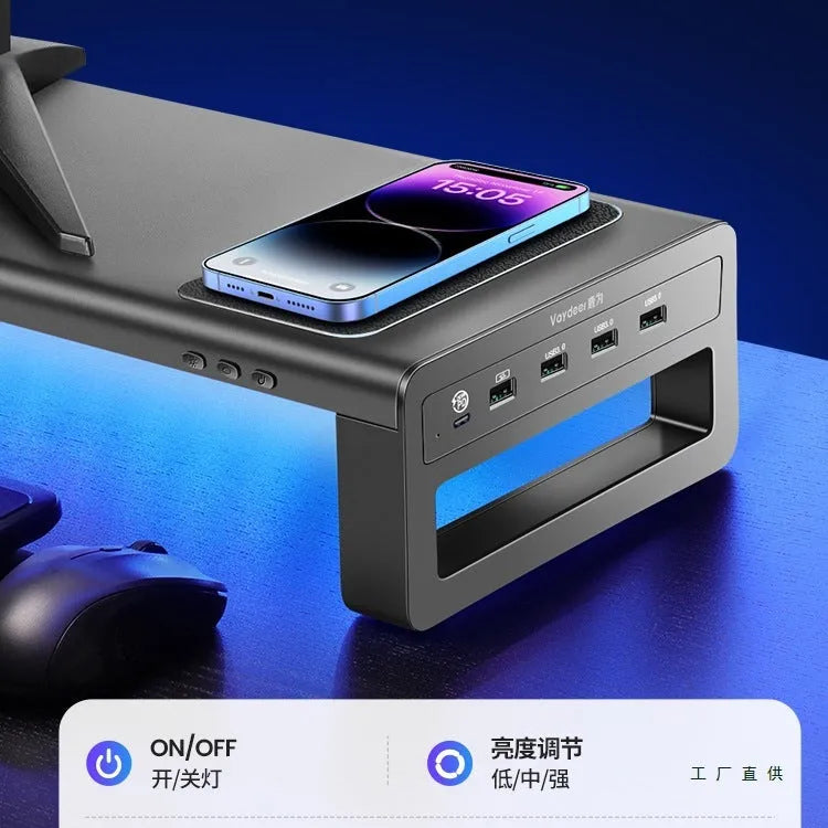 Desktop screen stand with drawer in black, featuring USB and wireless charging ports under monitor