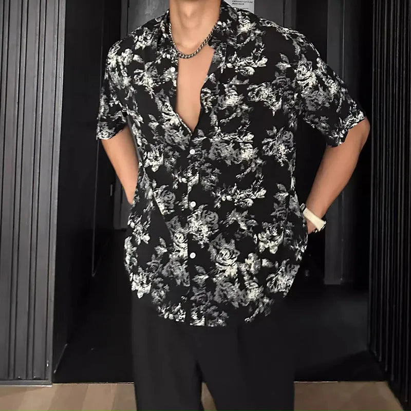 Man wearing a loose black floral print casual short sleeve shirt.