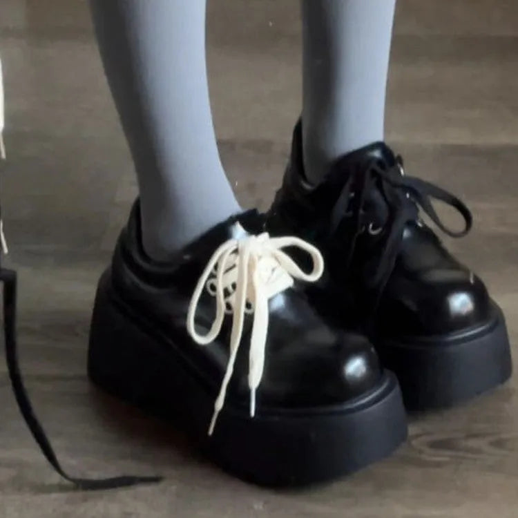 Women's matte black lace-up shoes with a high muffin heel and thick rubber sole.
