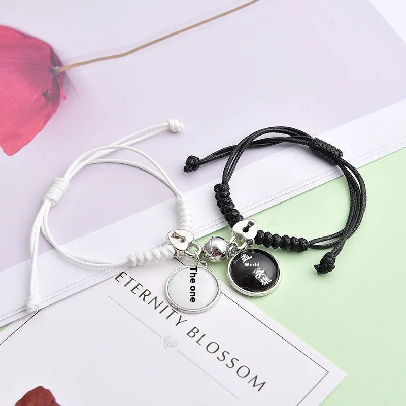 Pair of magnetic suction bracelets with alloy charms in various love and friendship themed designs on a wrist.
