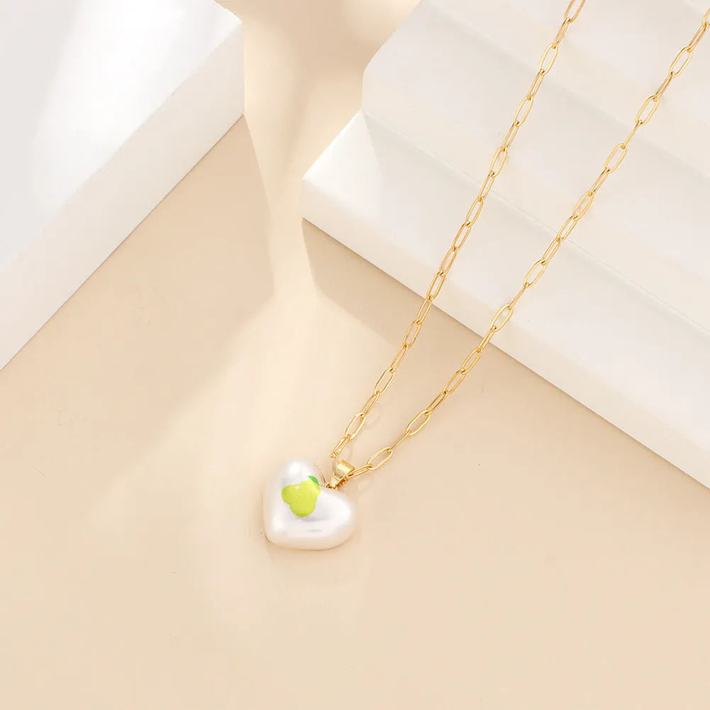 Geometric fruit charm necklace with an adjustable chain, shown in strawberry, pineapple, apple, pear, and cherry colour variants.