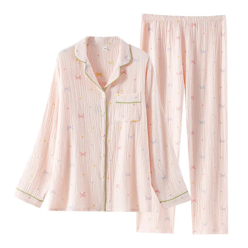 Women's pink cotton long-sleeve pajama top and trousers set laid flat.