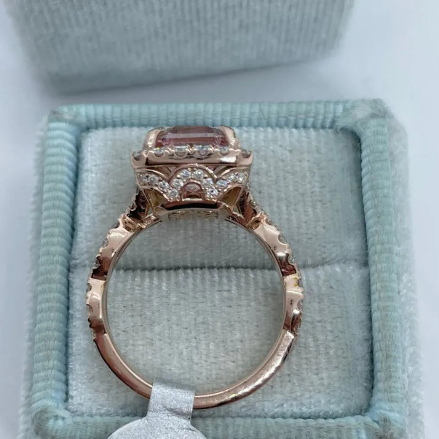 Rose gold geometric alloy ring on a plain background
