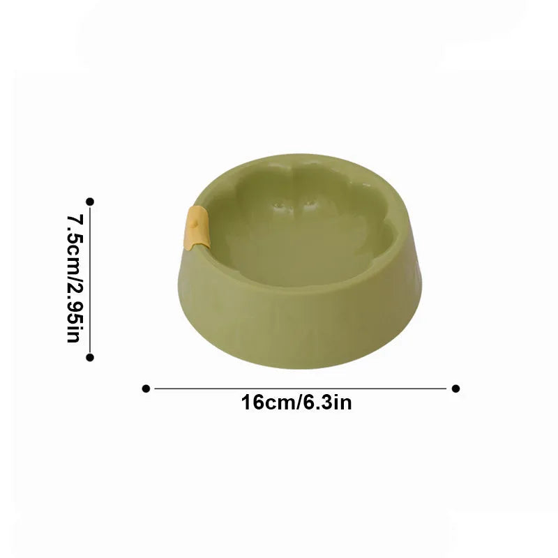 Green plastic double pet bowl for dog and cat food and water on a white surface