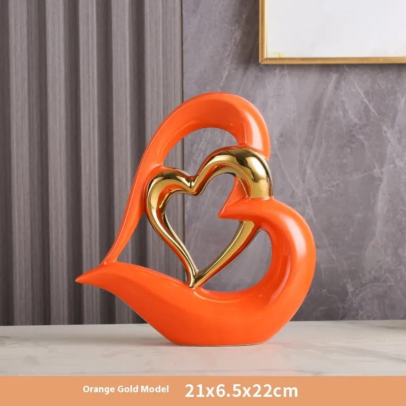 Modern white porcelain heart ornament in a metallic finish, showing its geometric shape on a table.
