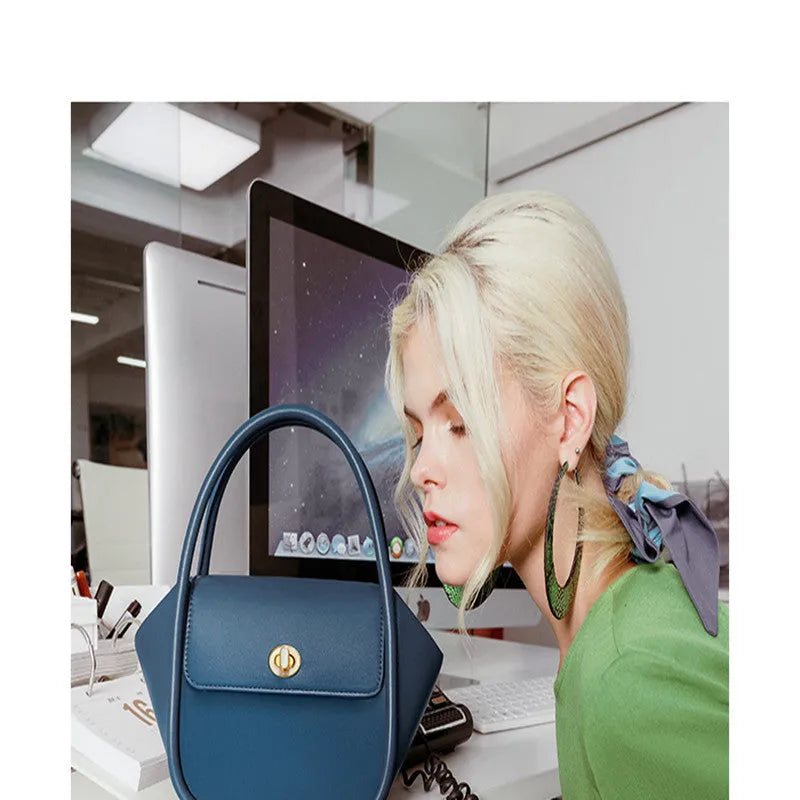Women's leather wing-shaped tote bag with buckle closure in blue, grey, black, or brown colour options
