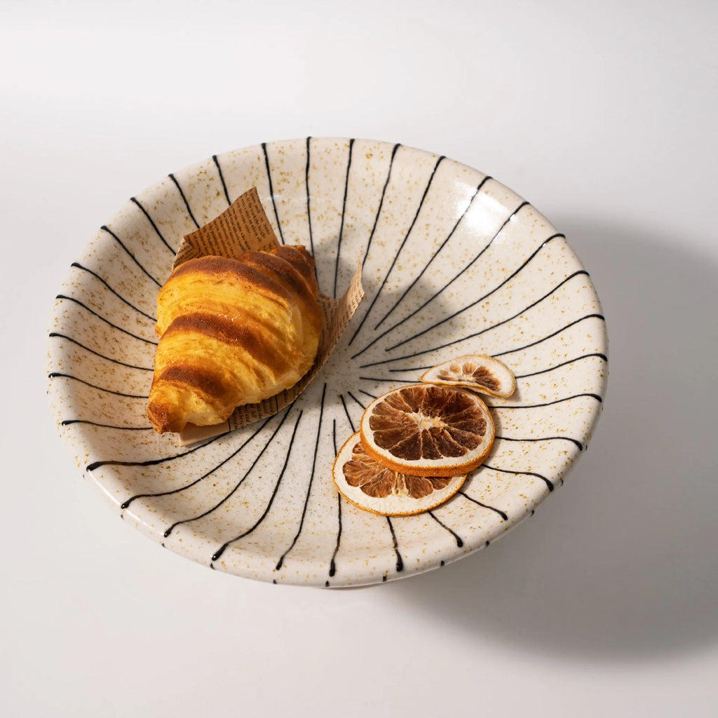 Black and white striped synthetic resin fruit plate or dessert plate on a table