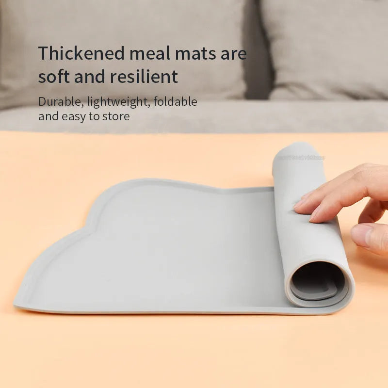 Blue silicone cat head-shaped pet feeding mat on a wooden floor.