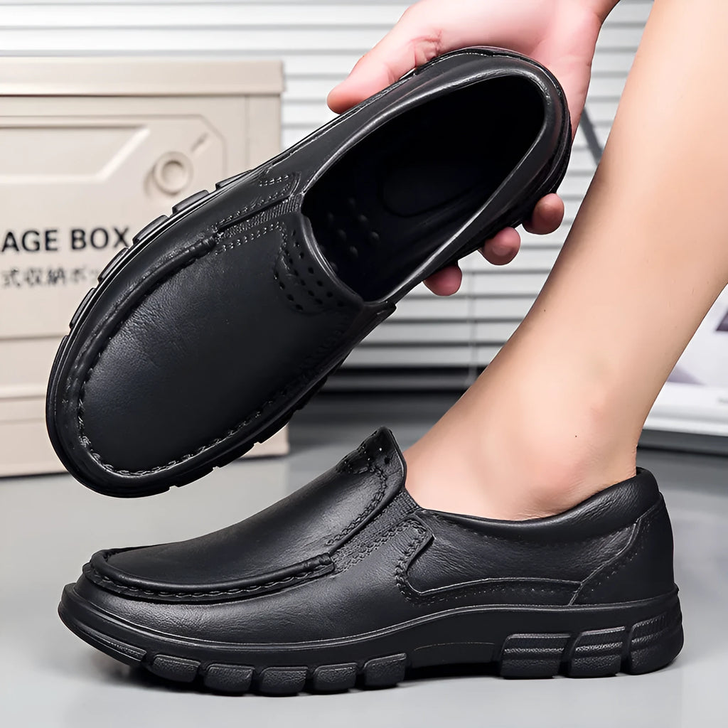Men's black slip-on work shoes with a mid-top waterproof artificial leather upper and platform sole.