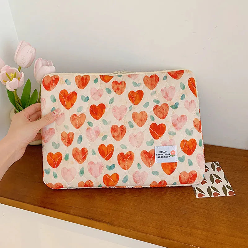 Floral print cloth laptop bag in green flower, pink floral, red flower, and red heart designs, showing three size options.