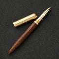 Brass and sandalwood solid wood signature pen with wooden barrel and brass fittings on a desk