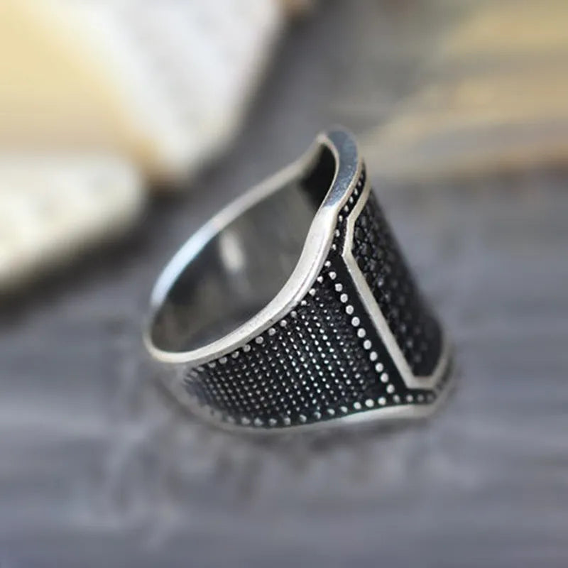 Black alloy ring with a zircon stone and copper inlay detail, shown in a unisex style.