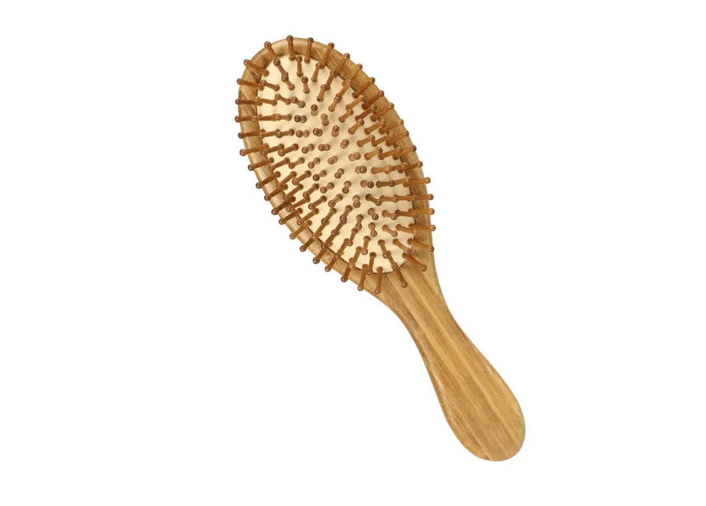 Carbonised bamboo massage comb 66x218mm on neutral background with smooth wooden surface visible