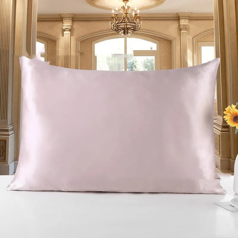 19 M double-sided silk pillowcase in apricot colour on a bed.