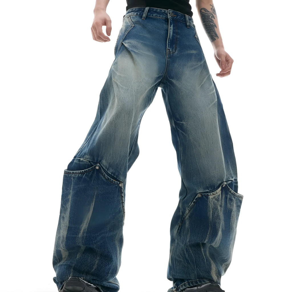 Man wearing verdant blue retro washed burst pattern loose fit jeans with a curved knife design.
