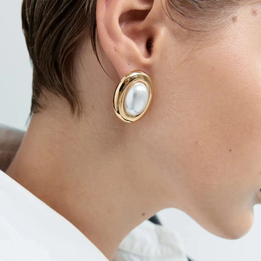 A pair of stainless steel vintage pearl stud earrings for women with an electroplated finish.