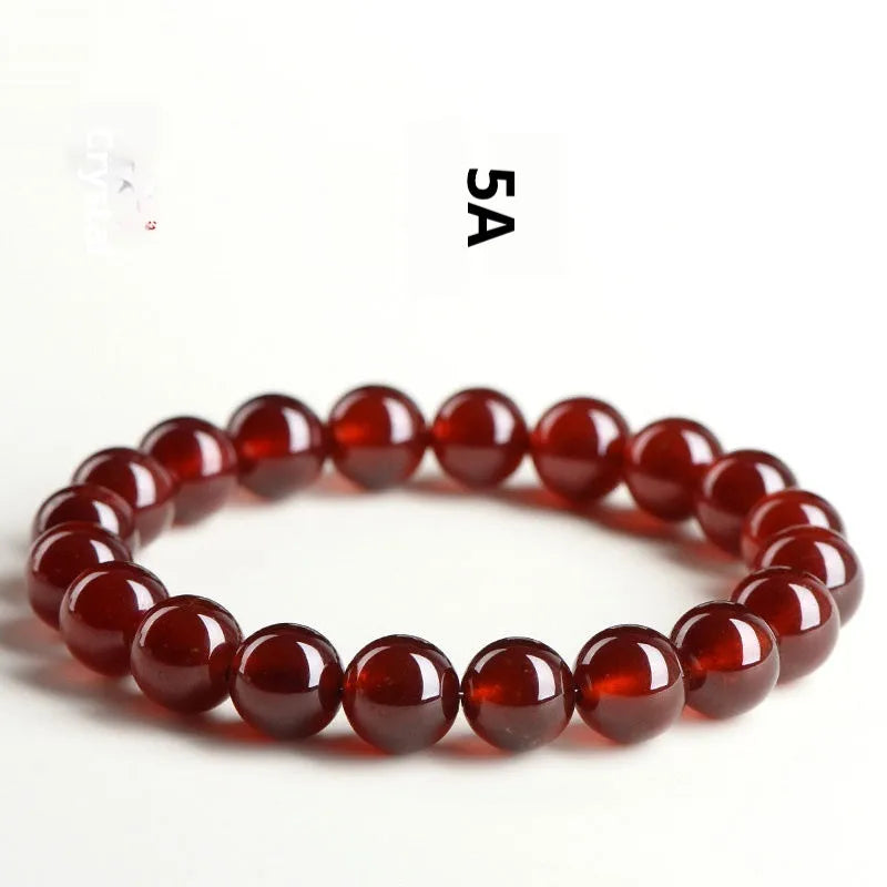 Natural orange red garnet ball bracelet in retro unisex style on wrist, showing crystal links and ruyi design details.
