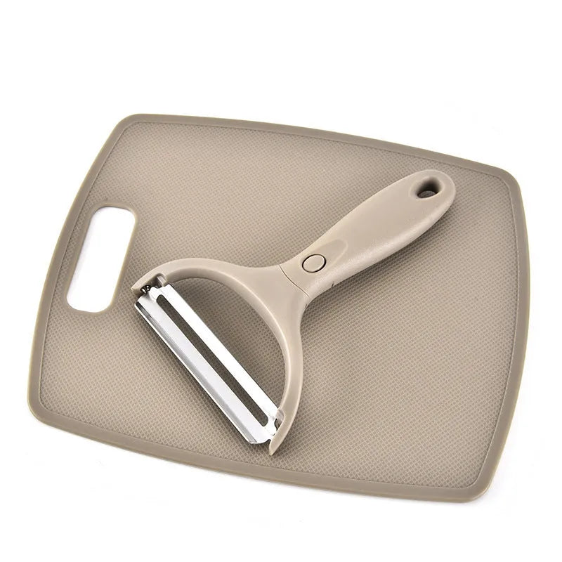 Green stainless steel cutter set with wheat straw chopping board, peeler, and fruit knife on a table