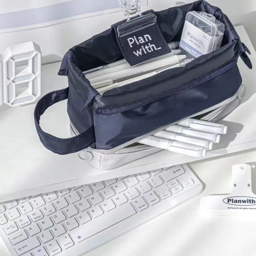 A dark blue folding double-layer pencil case made from polyester fabric, shown open to reveal internal dividers.