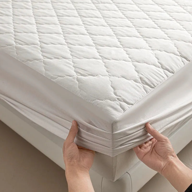 Diamond lattice quilted waterproof mattress protector and pillowcases in a solid colour.