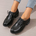 Black women's low-top work shoes with a chunky heel, PU leather upper, and rubber sole.