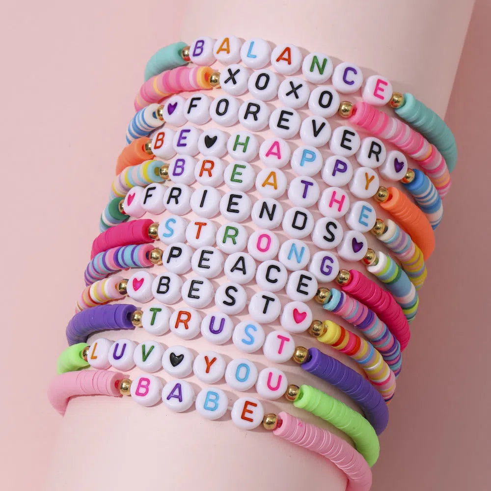 Children's polymer clay bracelet with dinosaur bead theme on a white background