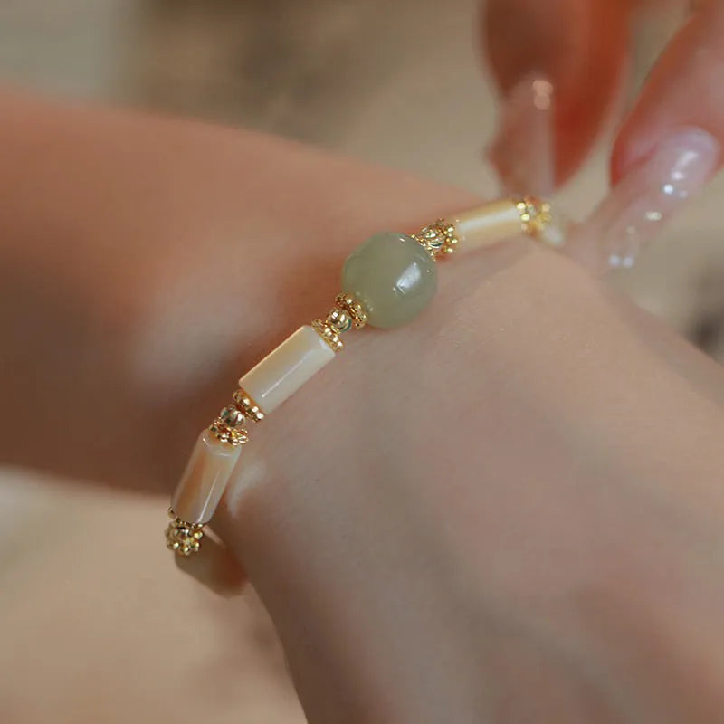 Handmade women's Hetian jade bracelet with round beads in geometric design on wrist