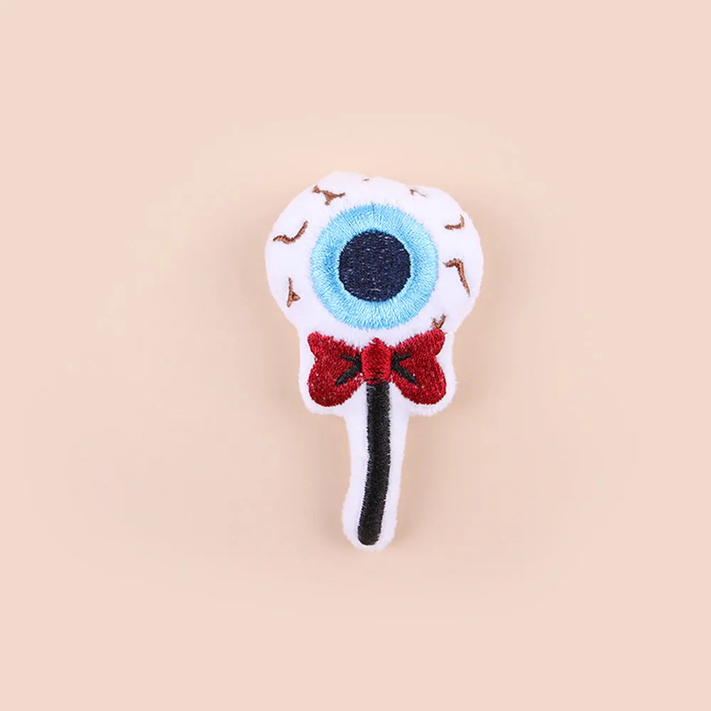 Plush cat teaser toy with three interchangeable heads: eyes, candy, and skull designs