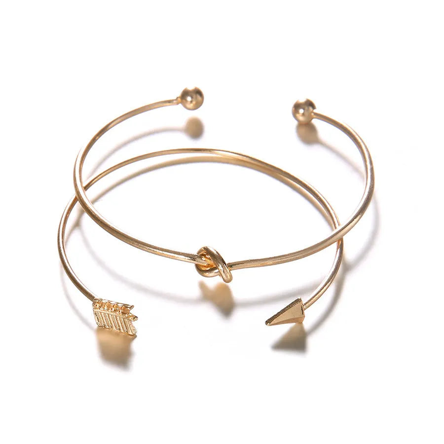 Gold electroplated alloy vintage cuff bracelet with arrow and knot design for women