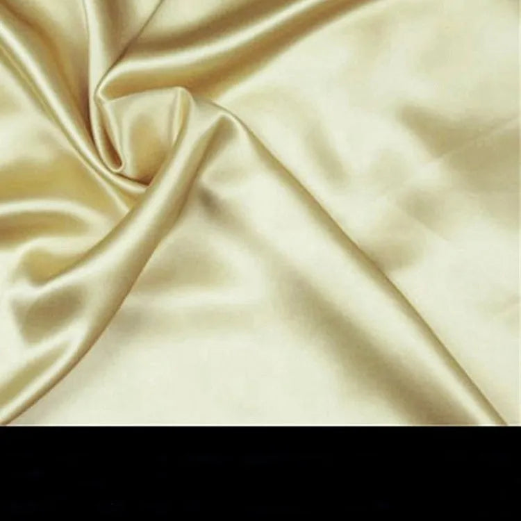 19 M double-sided silk pillowcase in apricot colour on a bed.