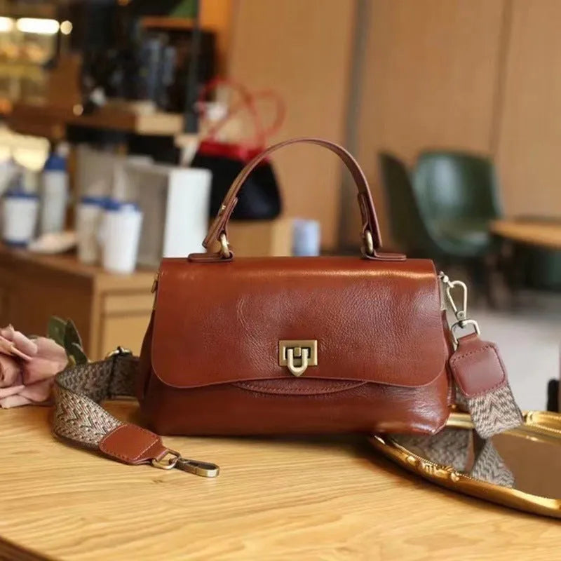 Women's dark brown genuine leather saddle back handbag with multiple compartments and shoulder straps