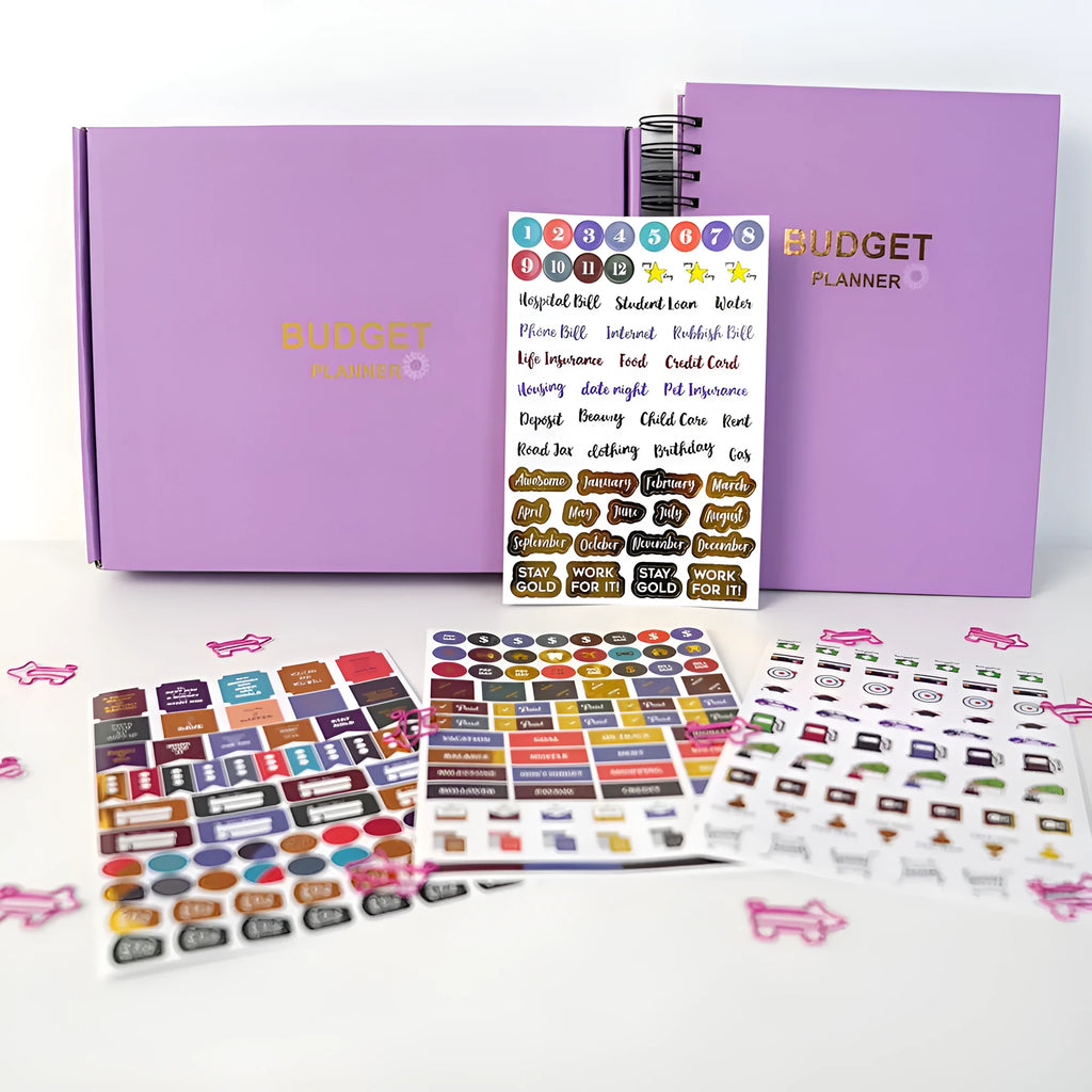 Purple coil-bound financial planning notebook with budgeting stickers and paper clips for monthly expense tracking