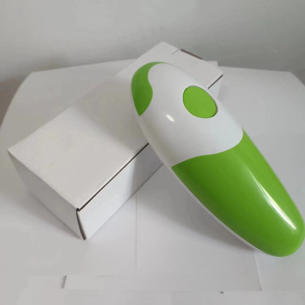 Electric can opener in light green plastic with iron box mechanism, 16x6.5x4.8cm, on kitchen countertop
