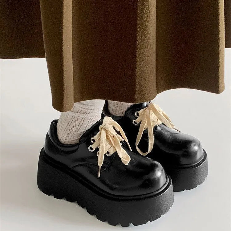 Women's matte black lace-up shoes with a high muffin heel and thick rubber sole.