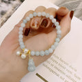 Emerald green jade bracelet with hand-carved gourd charm and pearl decoration in Chinese style