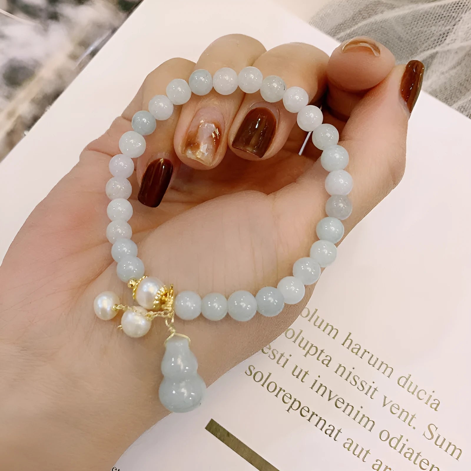 Emerald green jade bracelet with hand-carved gourd charm and pearl decoration in Chinese style