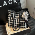 Black woven wool shoulder bag with horizontal square design showing internal organisation pockets and exterior sandwich compartment