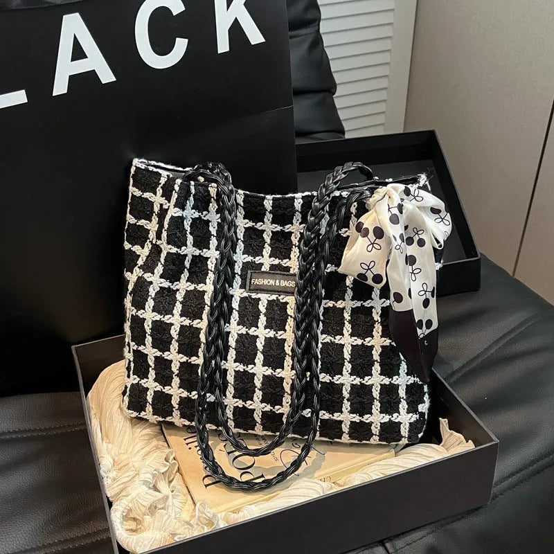Black woven wool shoulder bag with horizontal square design showing internal organisation pockets and exterior sandwich compartment