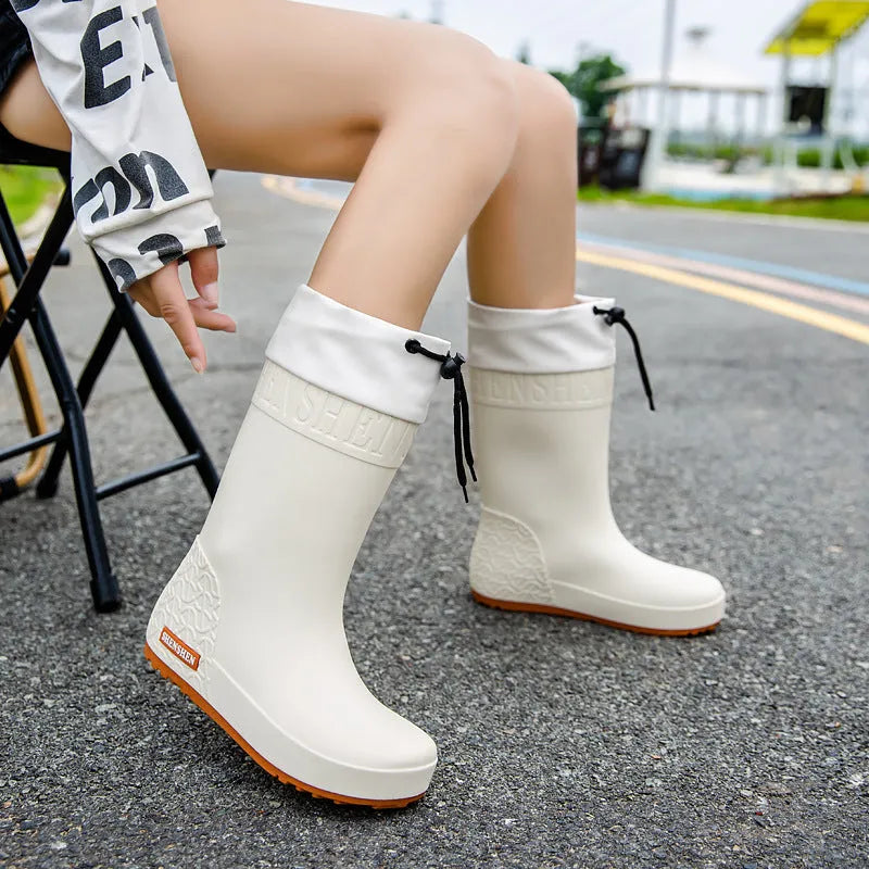 Women's solid colour PVC rain boots with non-slip soles in apricot, black, brown, and pink waterproof mouth options