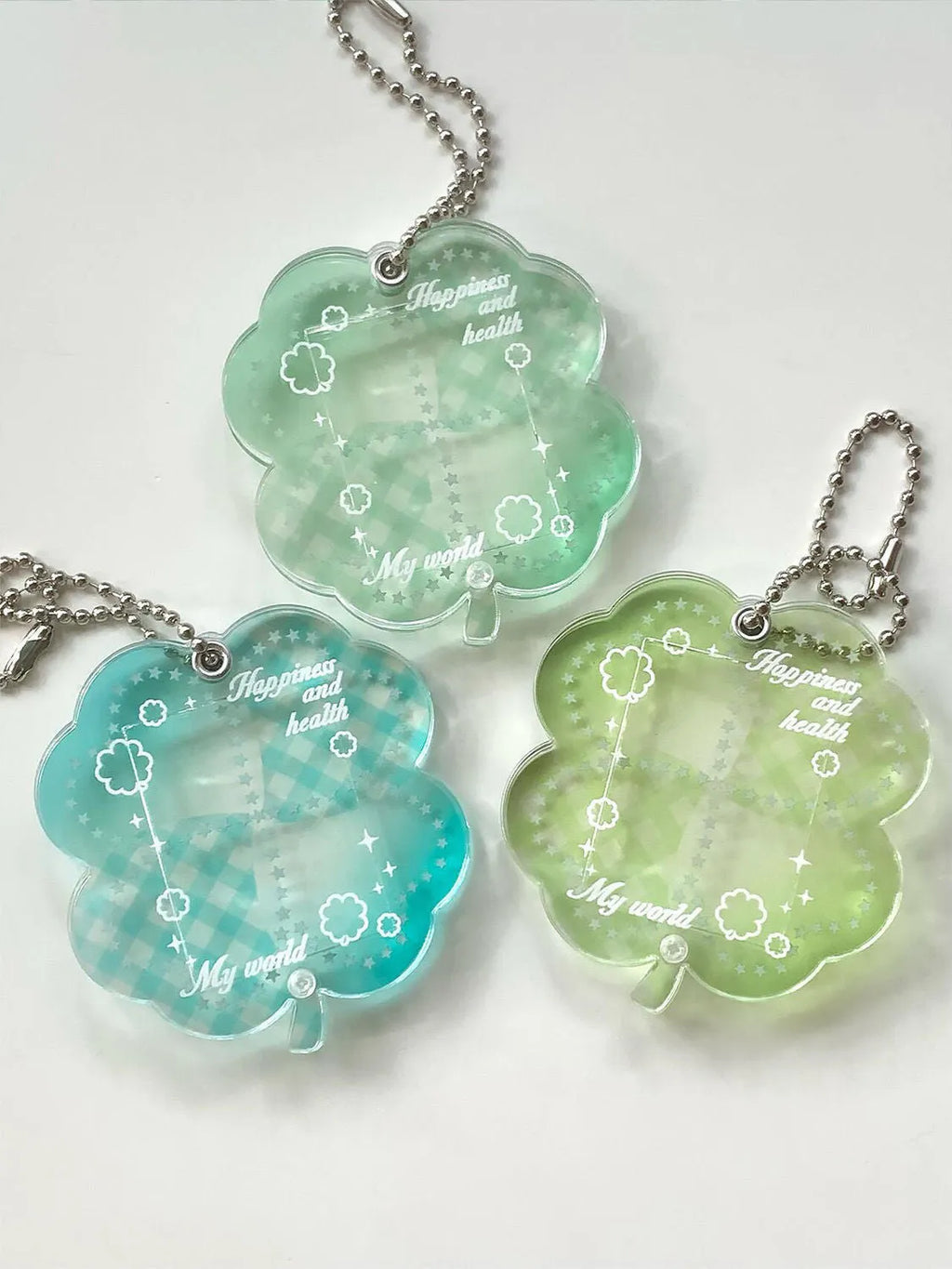 Acrylic four-leaf clover phone pendant keychain on a ring in blue, green, or mint.
