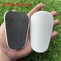 Extra small mini football shin guards in black and white colours measuring 8cm by 5cm