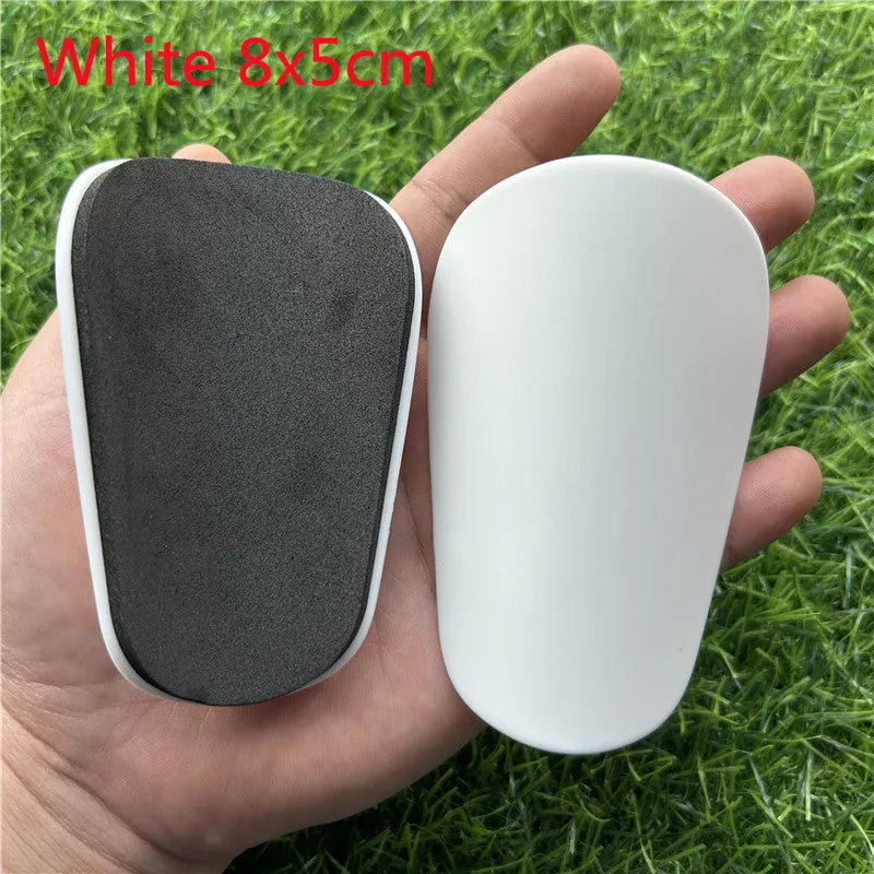 Extra small mini football shin guards in black and white colours measuring 8cm by 5cm