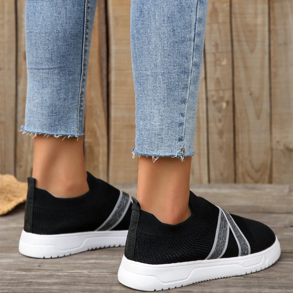 Black women's low-top flyknit mesh shoes with flat rubber sole and tassel detail.