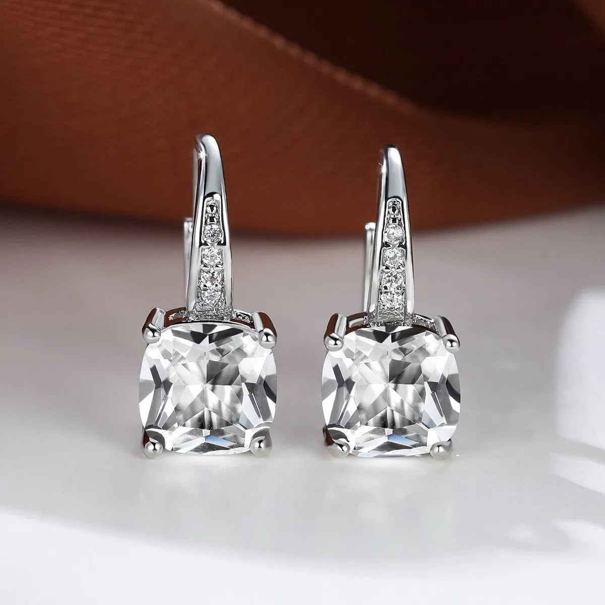 Square geometric ear hook studs with a round zircon stone, shown in a gold electroplated finish.