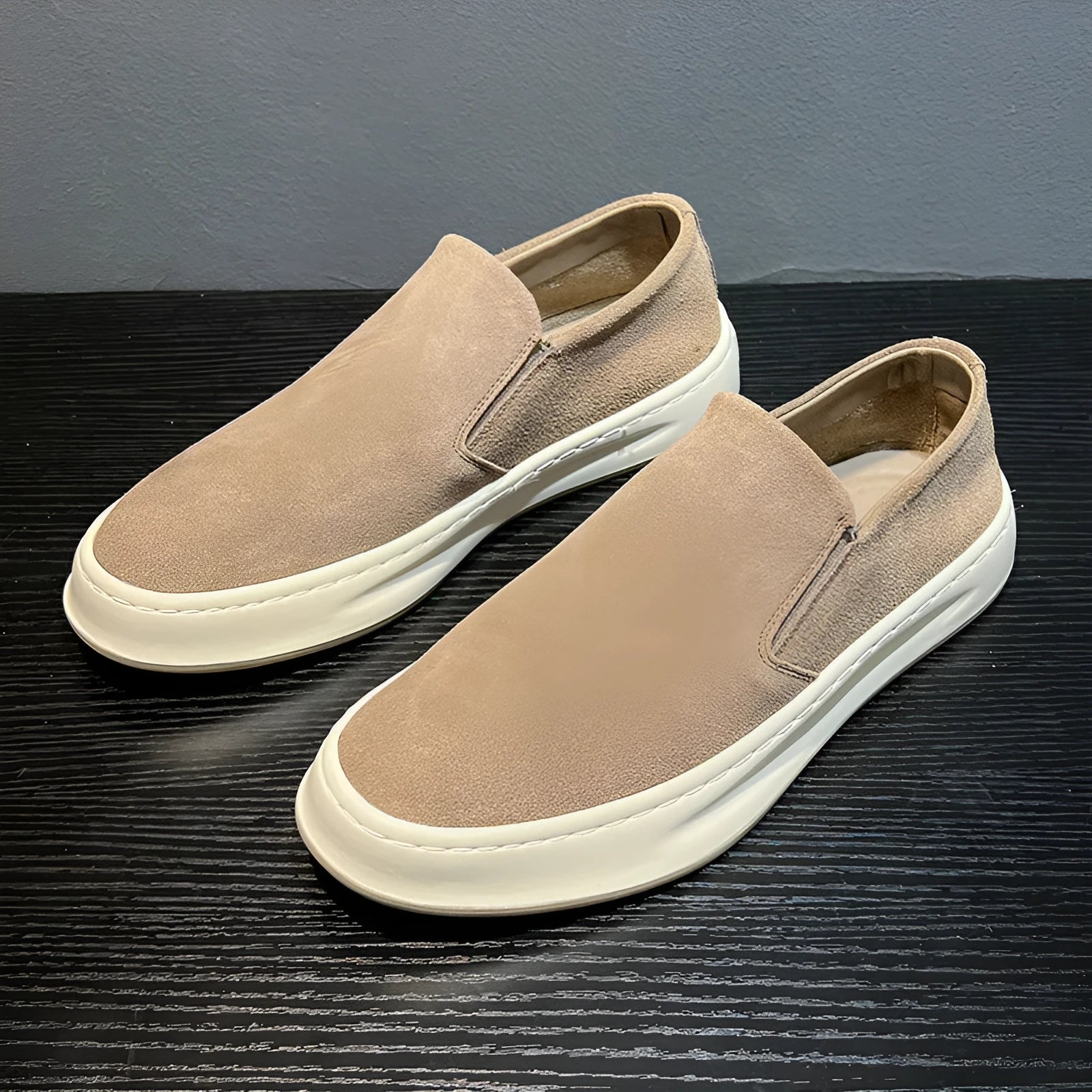 Men's grey slip-on casual shoes with round toe design and visible stitching details