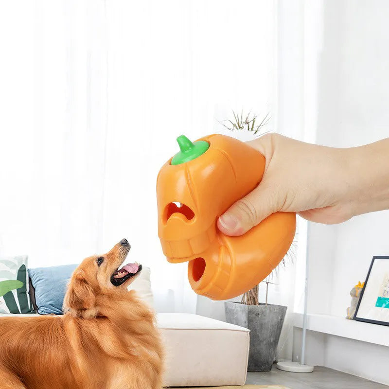 Orange Halloween pumpkin shaped rubber dog toy with a central treat-dispensing funnel.